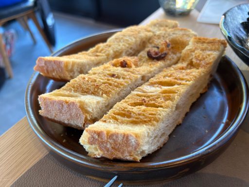 "Variedad de panes, mantequilla cremosa ahumada de ajos asados"